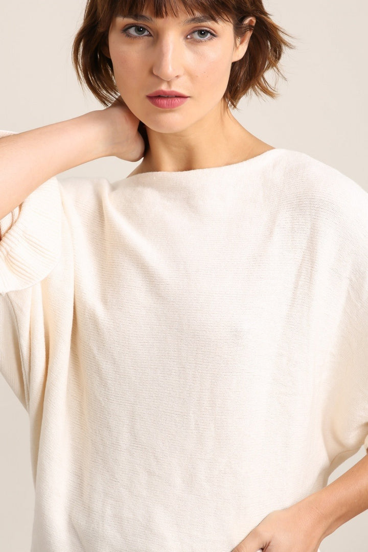 Woman wearing a white blouse against a plain background