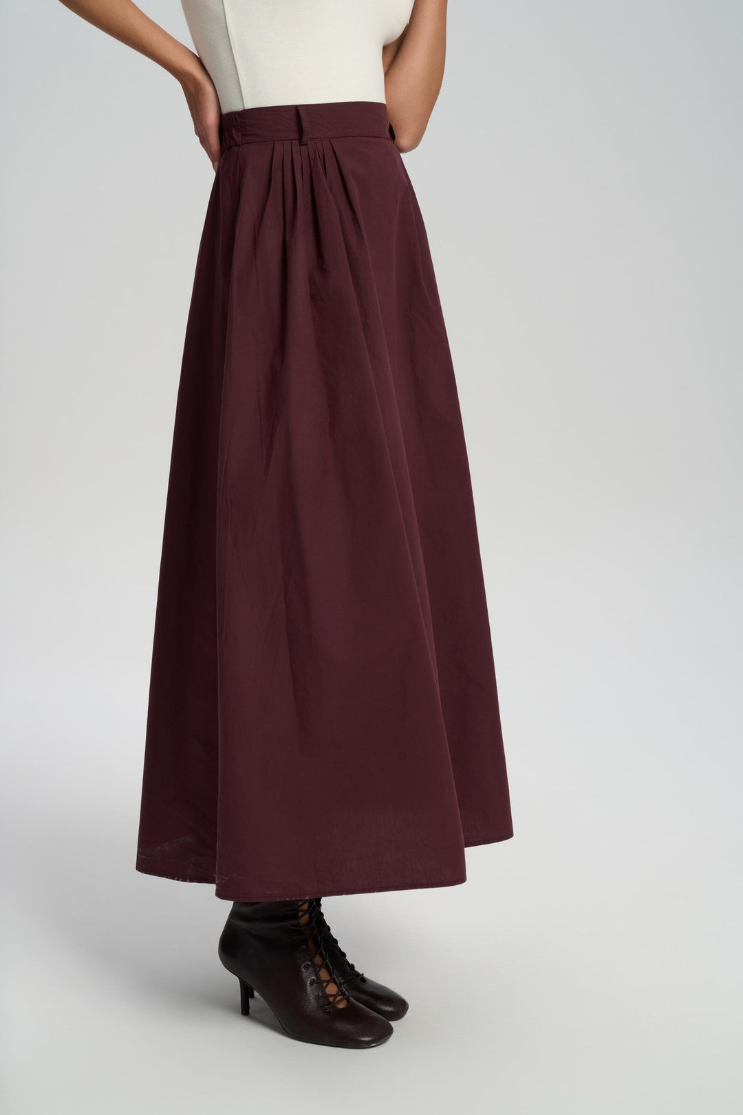 Person wearing a burgundy skirt on a white background