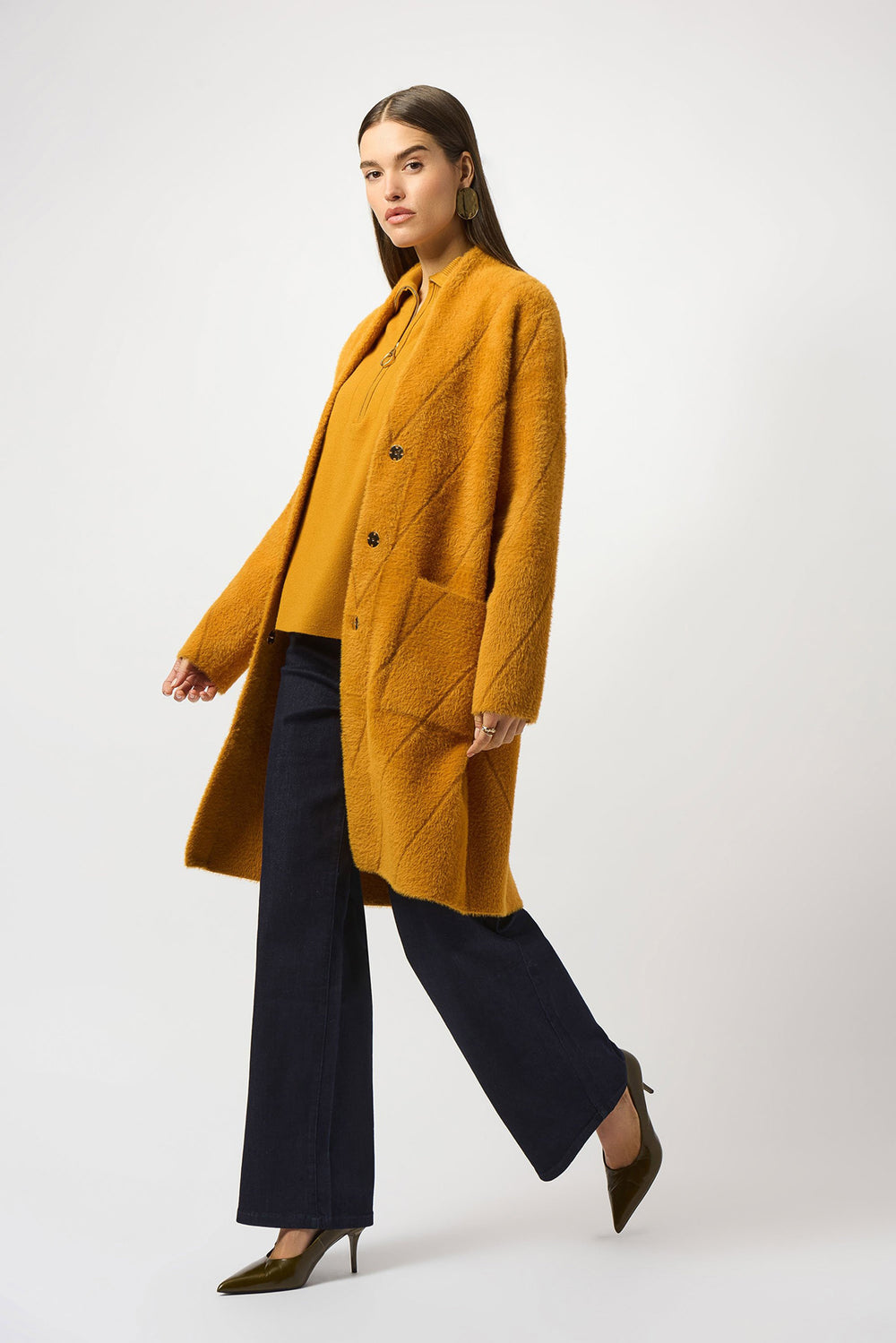 Woman wearing a mustard yellow coat on a white background
