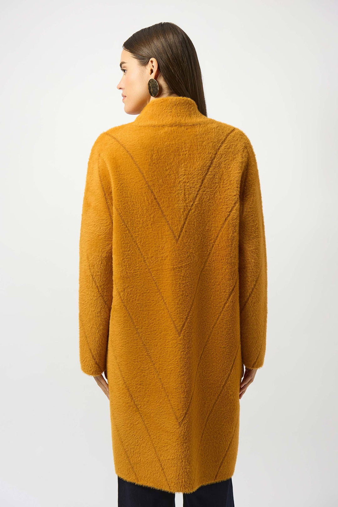 Woman wearing a mustard yellow textured coat on a white background