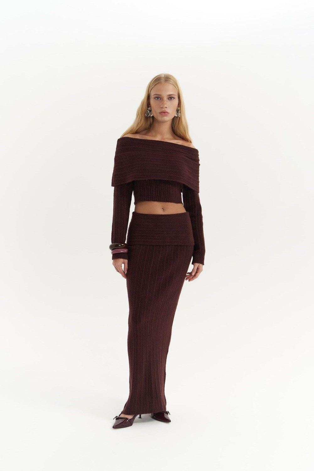 Woman wearing a brown off-shoulder top and skirt set on a white background