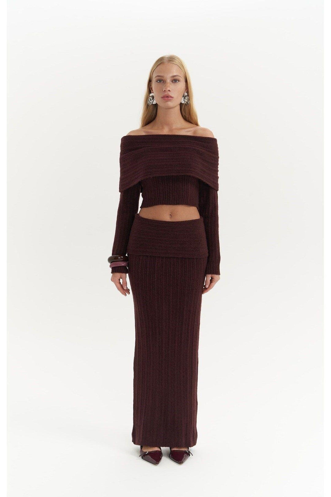Woman wearing a brown off-shoulder top and skirt set on a white background