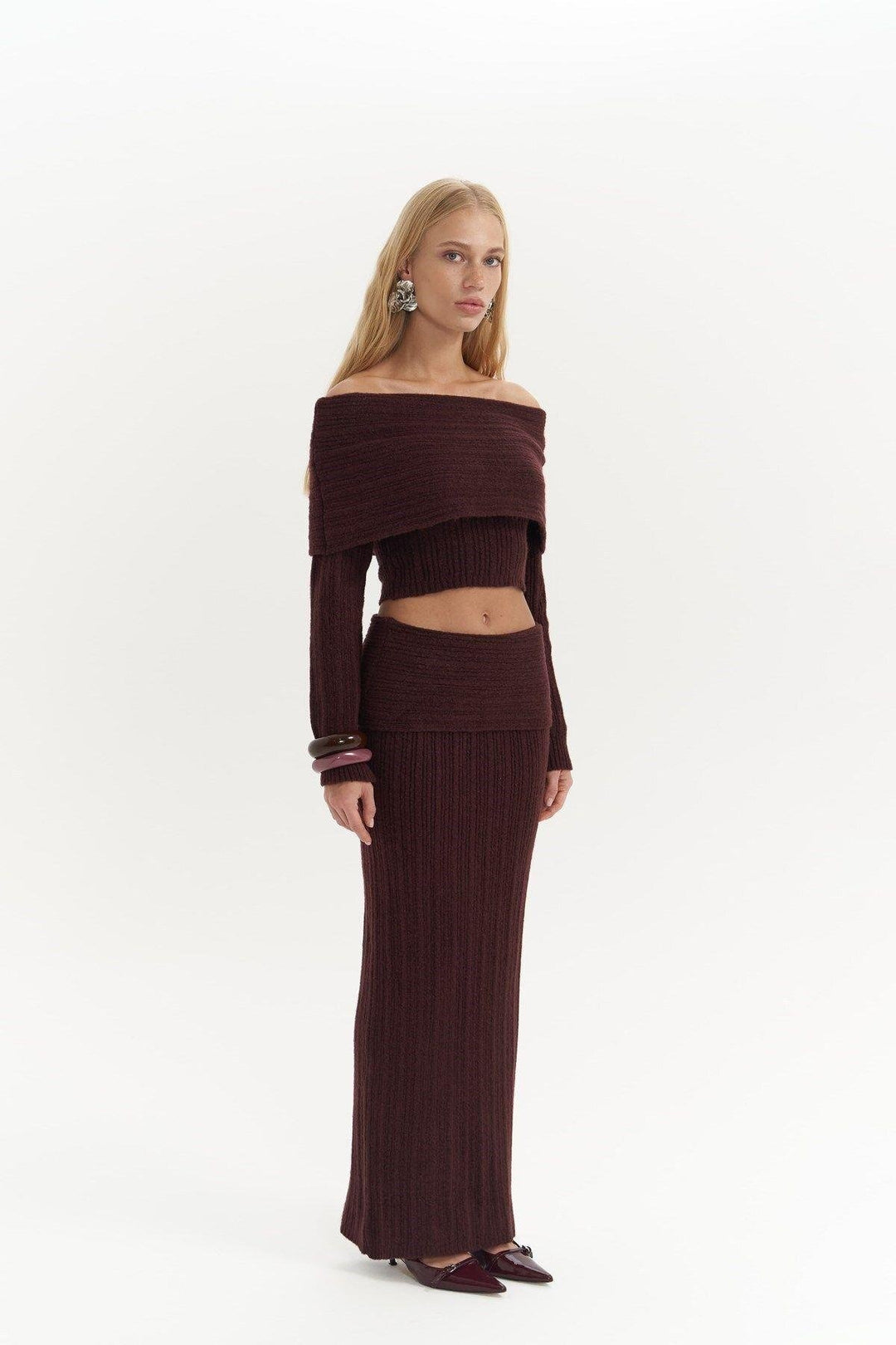 Woman wearing a brown ribbed knit outfit on a white background
