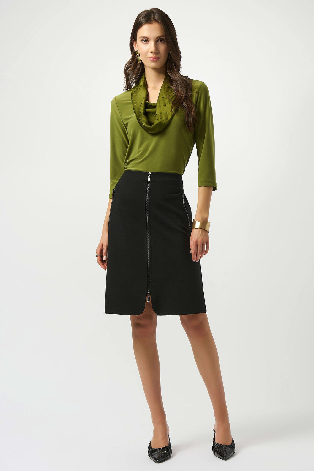 Woman wearing a green top and black skirt on a white background