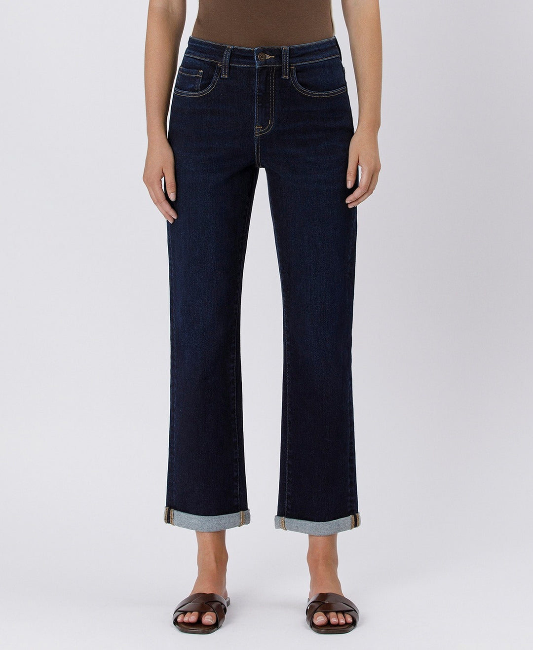 Dark blue jeans worn by a person on a white background
