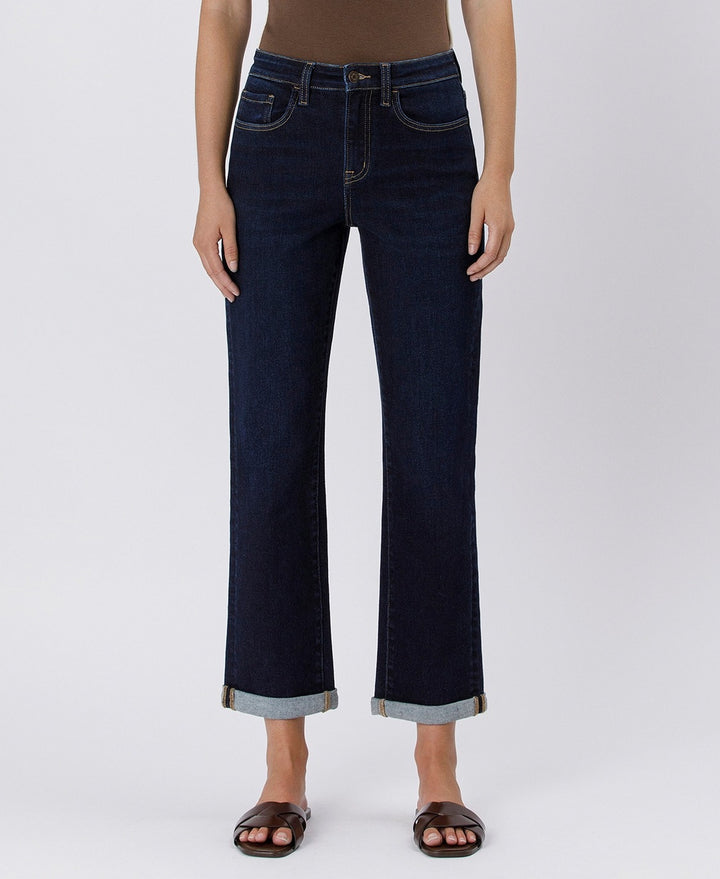 Dark blue jeans worn by a person on a white background
