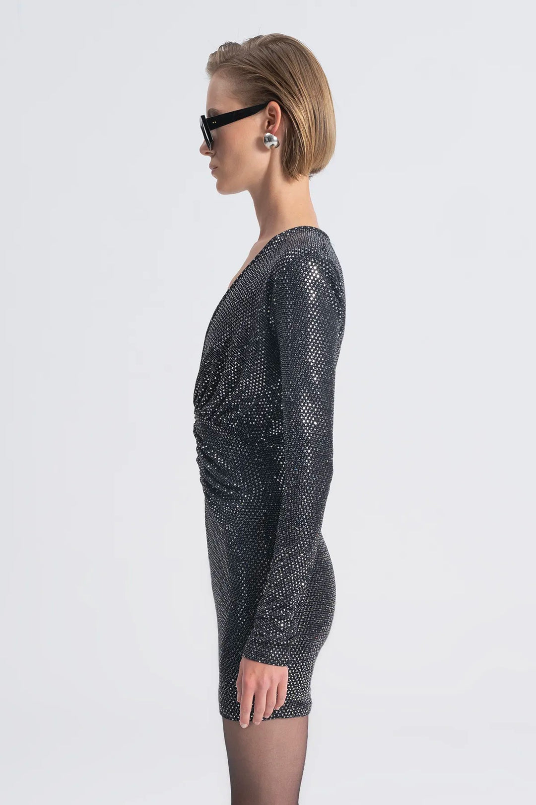 Woman wearing a sparkly black dress on a white background