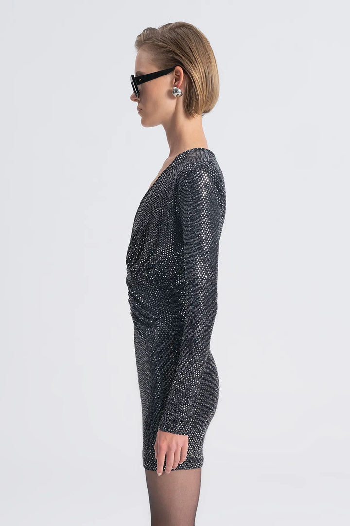 Woman wearing a sparkly black dress on a white background