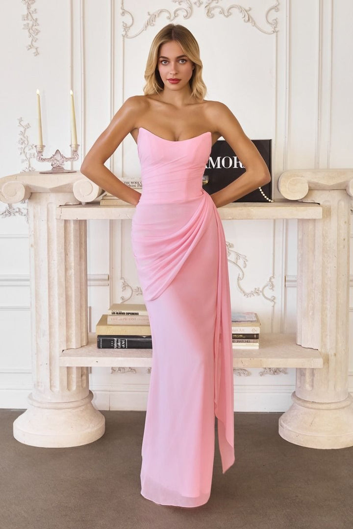 Woman in a pink strapless gown standing in an elegant interior setting.