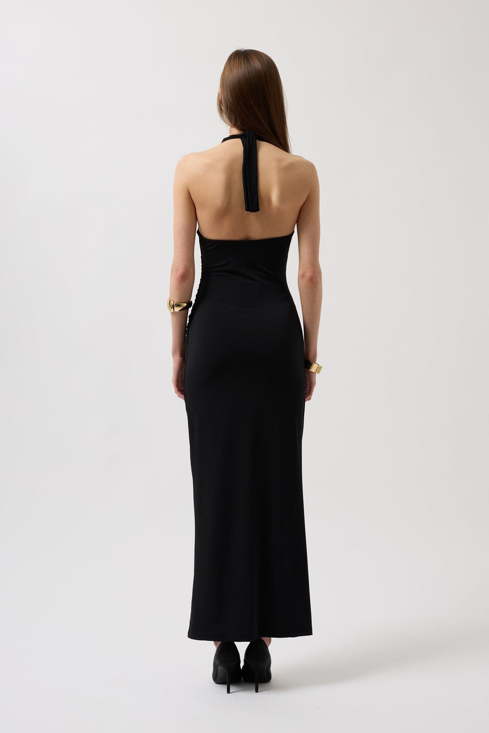 Woman wearing a black halter neck dress on a white background