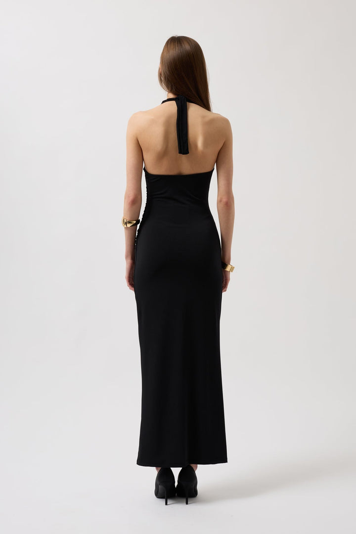 Woman wearing a black halter neck dress on a white background