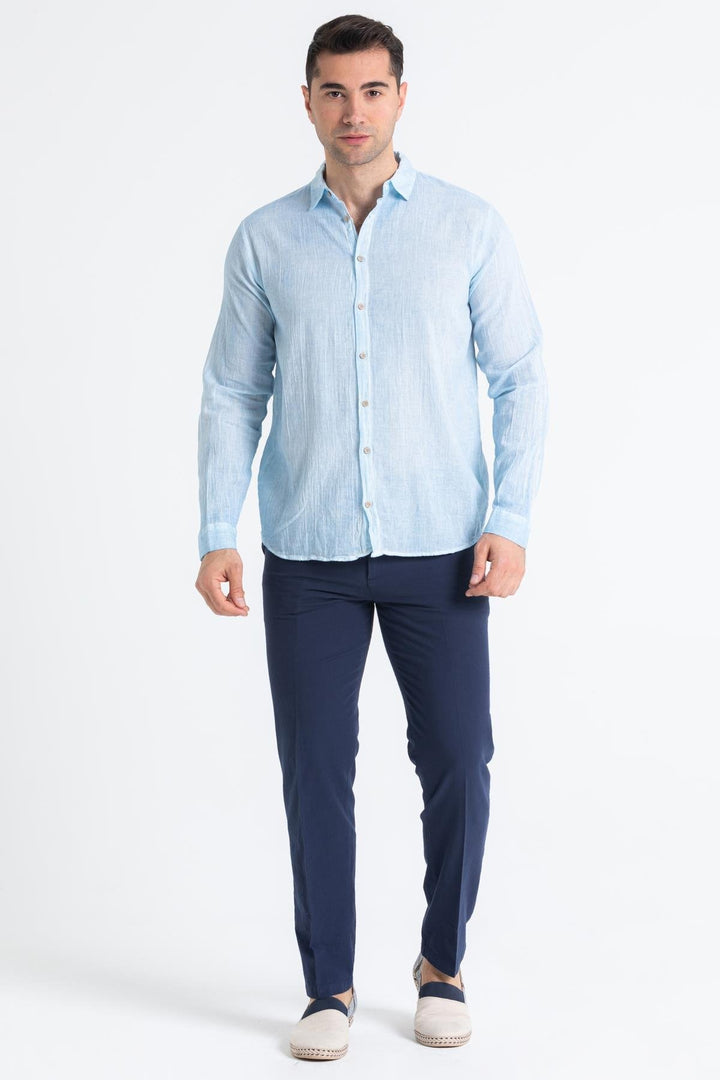 Effortless summer outfit with Mediterranean blue shirt styled with beige trousers and loafers