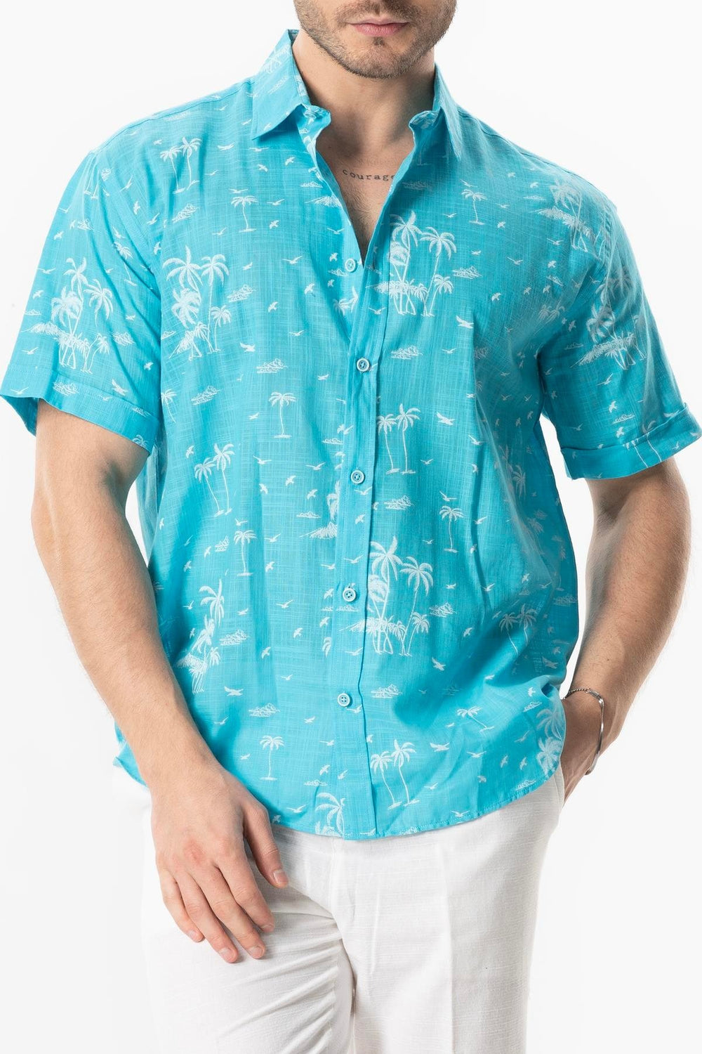 Man wearing a turquoise shirt with white palm tree pattern on a white background