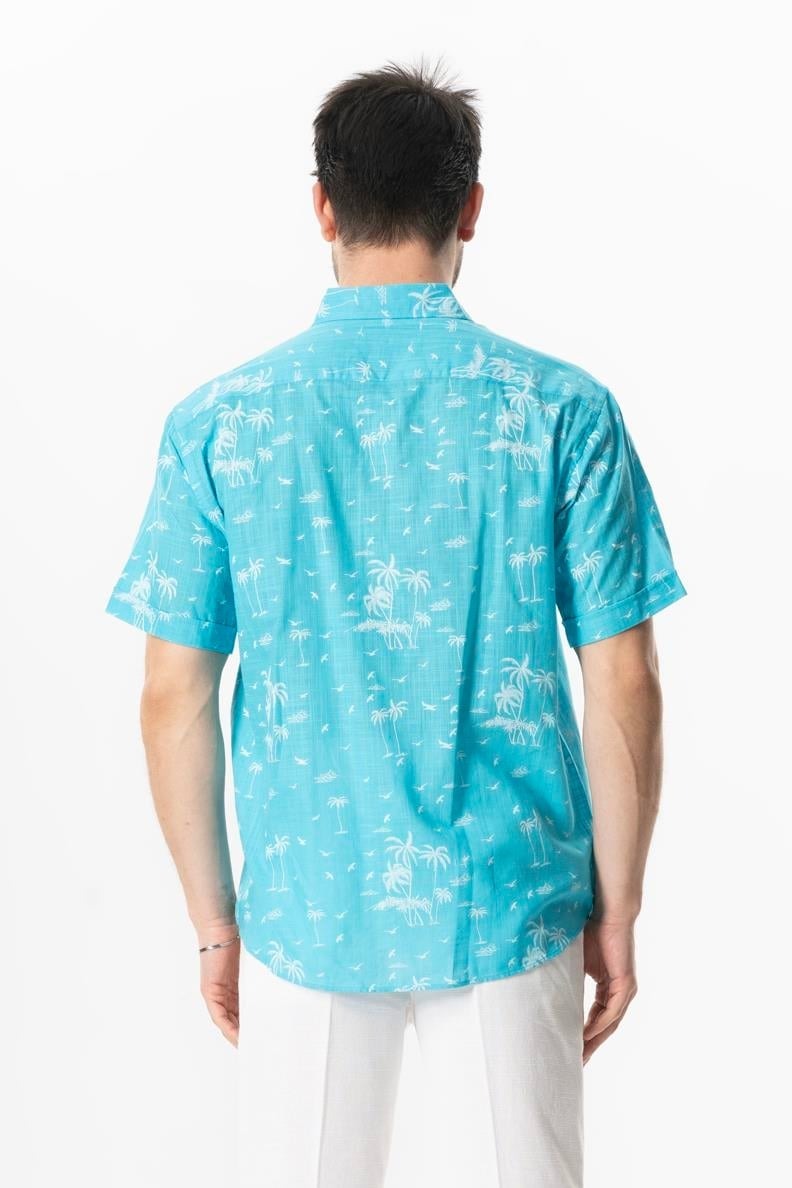 Person wearing a turquoise patterned shirt on a white background