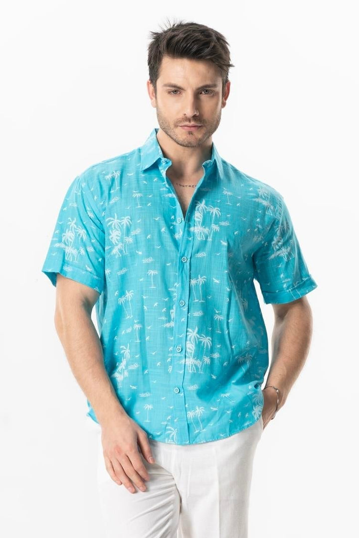 Man wearing a turquoise patterned shirt on a white background