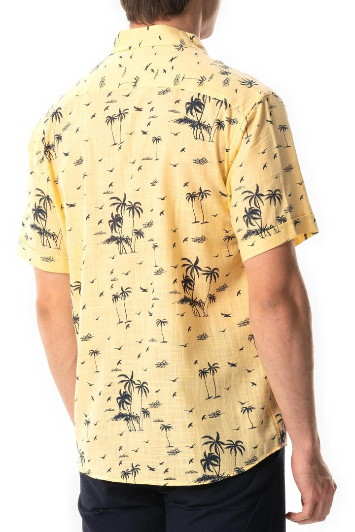 Person wearing a yellow shirt with black palm tree pattern on a white background