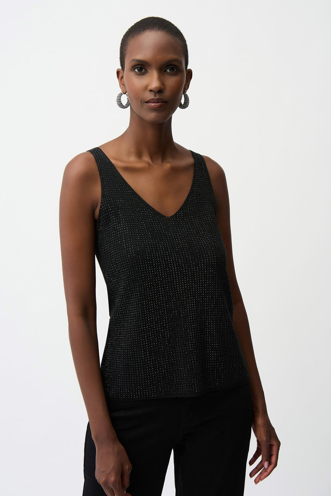 Woman wearing a black sleeveless top against a white background