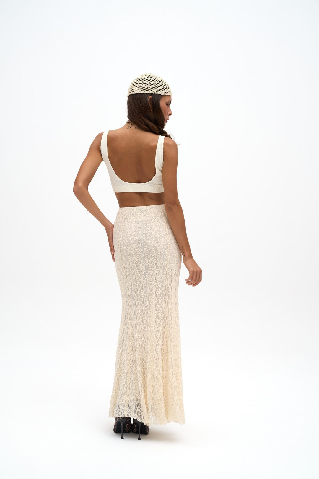 Woman wearing a white lace dress and headband on a white background
