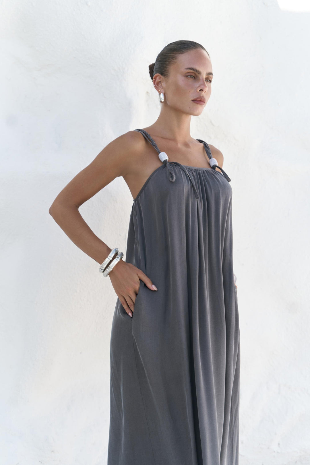 Woman wearing a gray dress against a white background