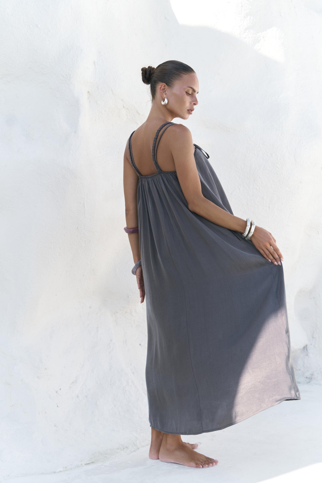 Woman wearing a gray dress against a white background