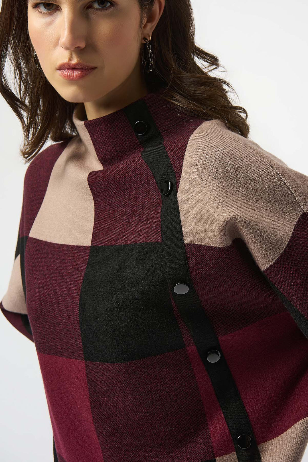 Woman wearing a checkered coat with a neutral background