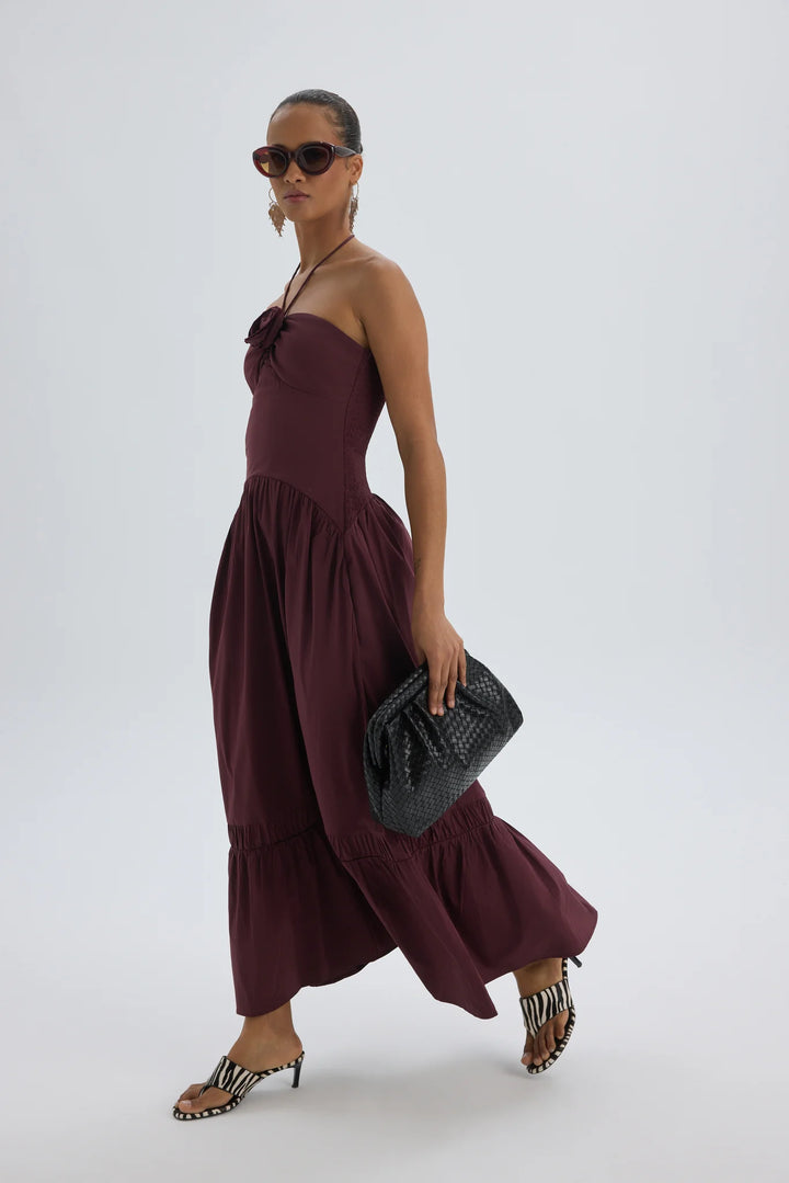 Woman wearing wine strapless maxi dress for elegant Mediterranean resort evening styling