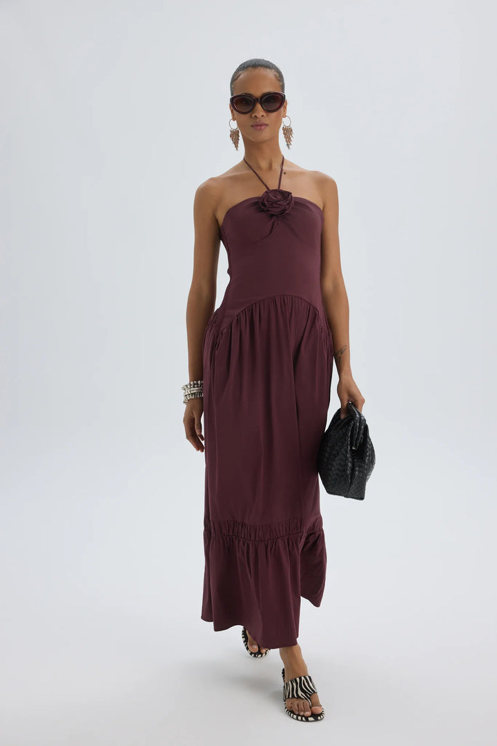 Woman wearing a burgundy one-shoulder dress on a white background