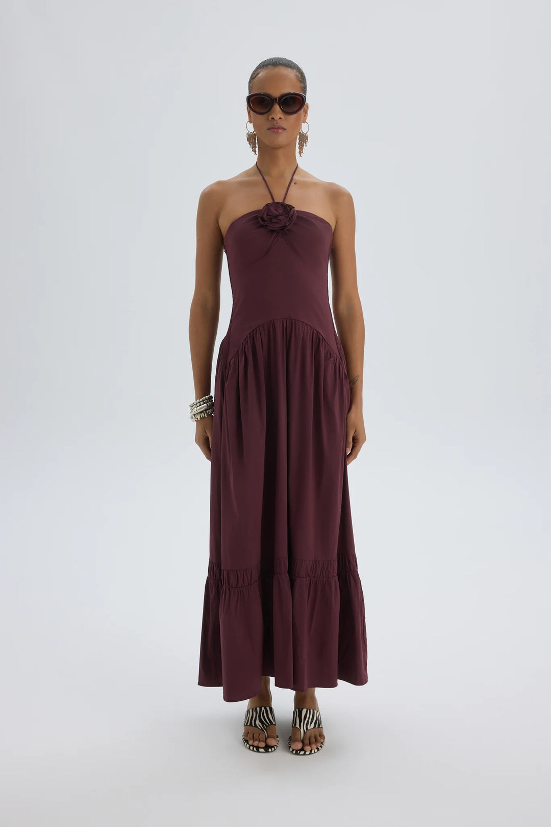 Woman wearing a burgundy strapless dress on a white background