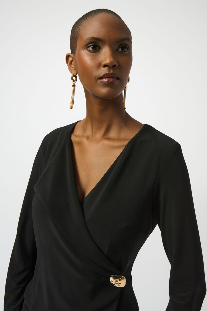 Woman wearing a black dress with a gold belt on a white background