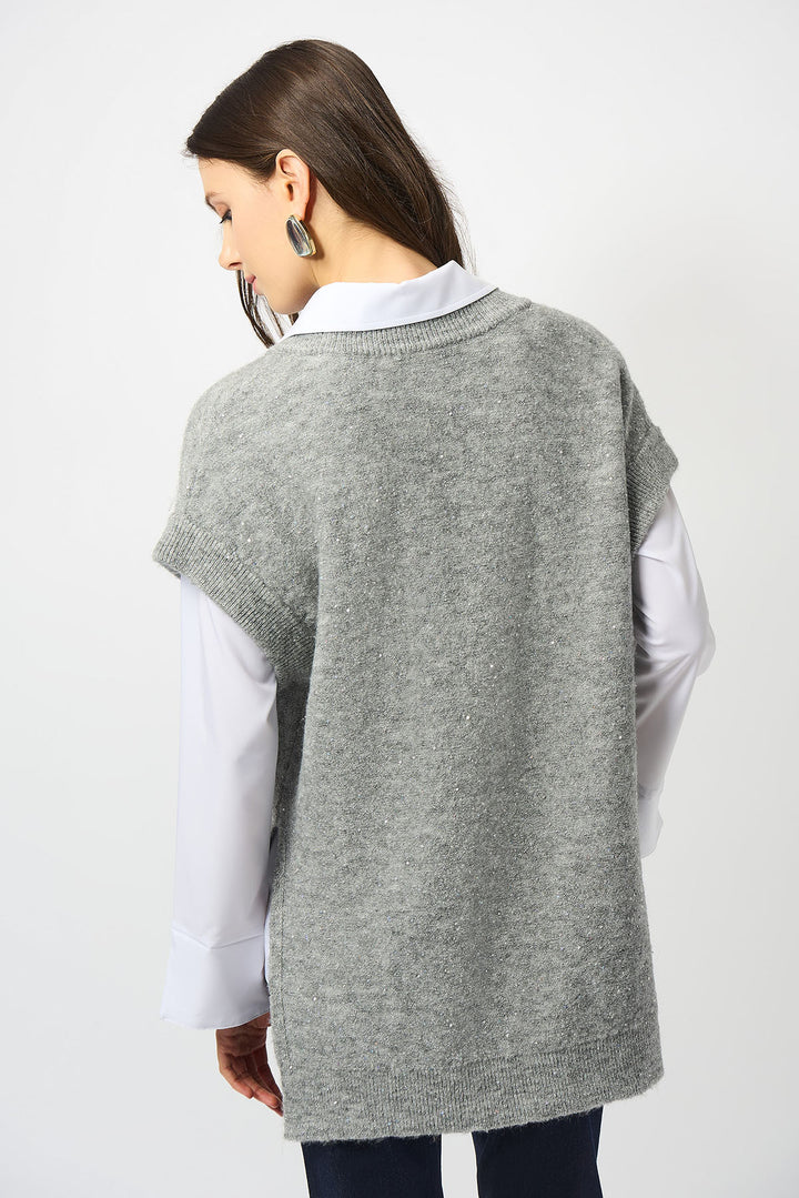 Woman wearing a gray sweater vest over a white shirt on a white background