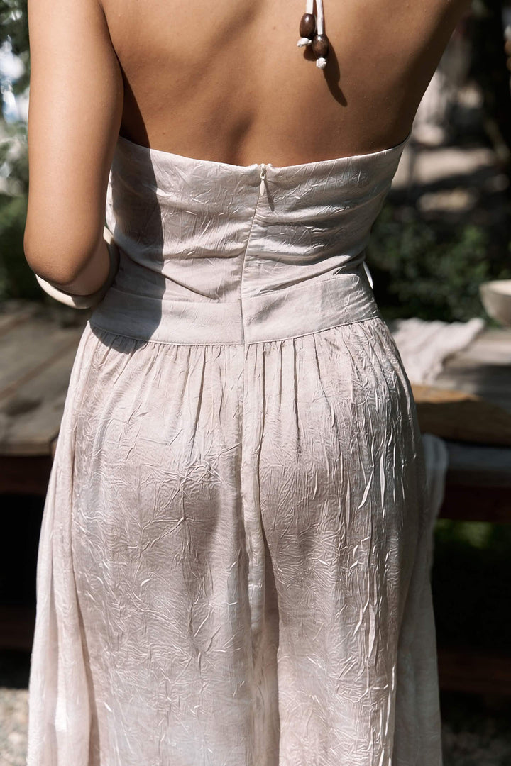 Light-colored dress with a textured pattern worn by a person outdoors.