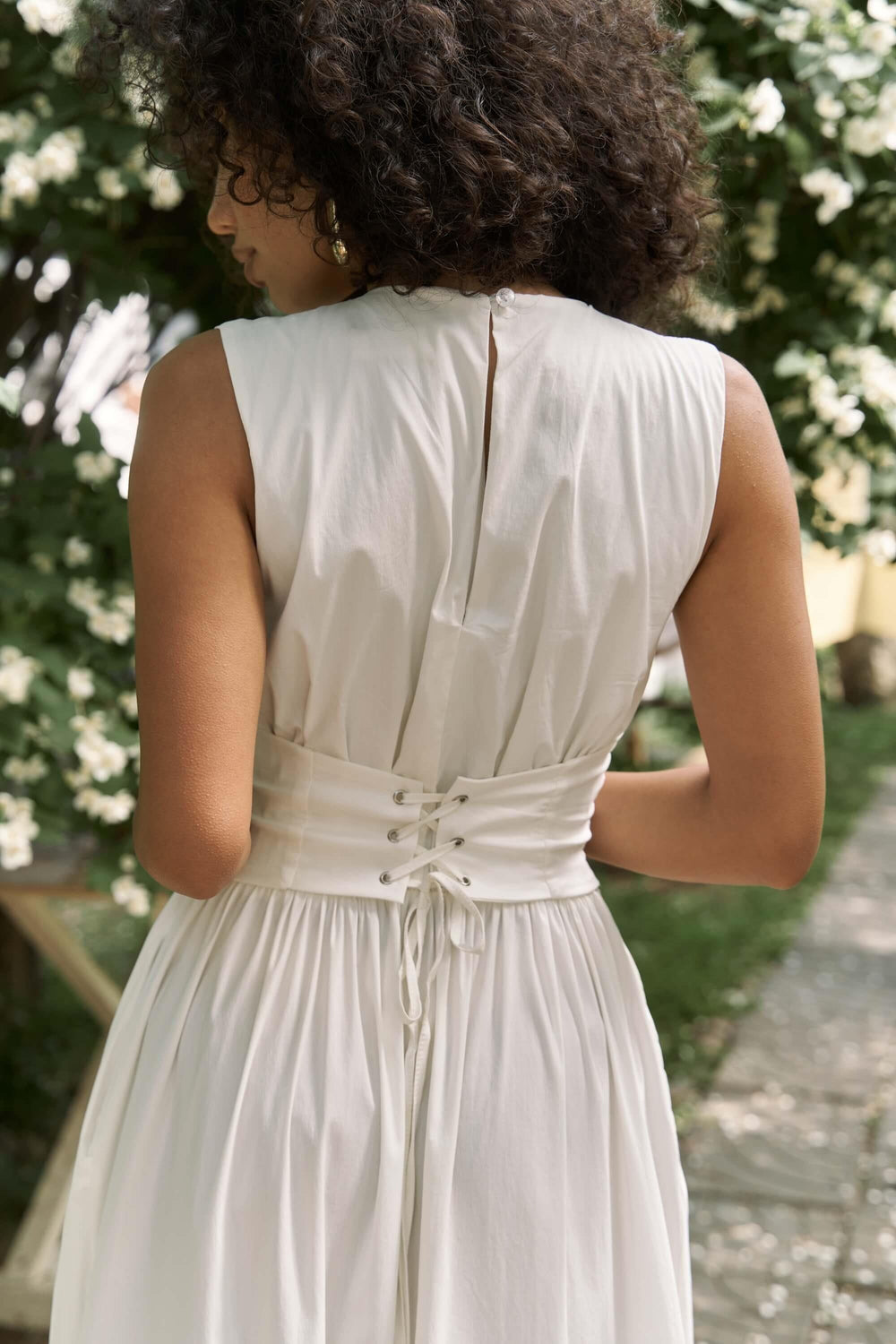 Person wearing a white dress with a floral background