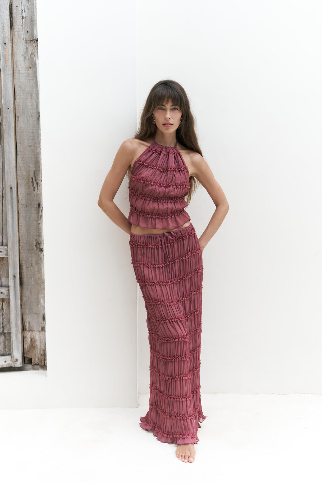 Woman wearing dusty rose matching crop top and skirt set for elegant summer resort wear styling